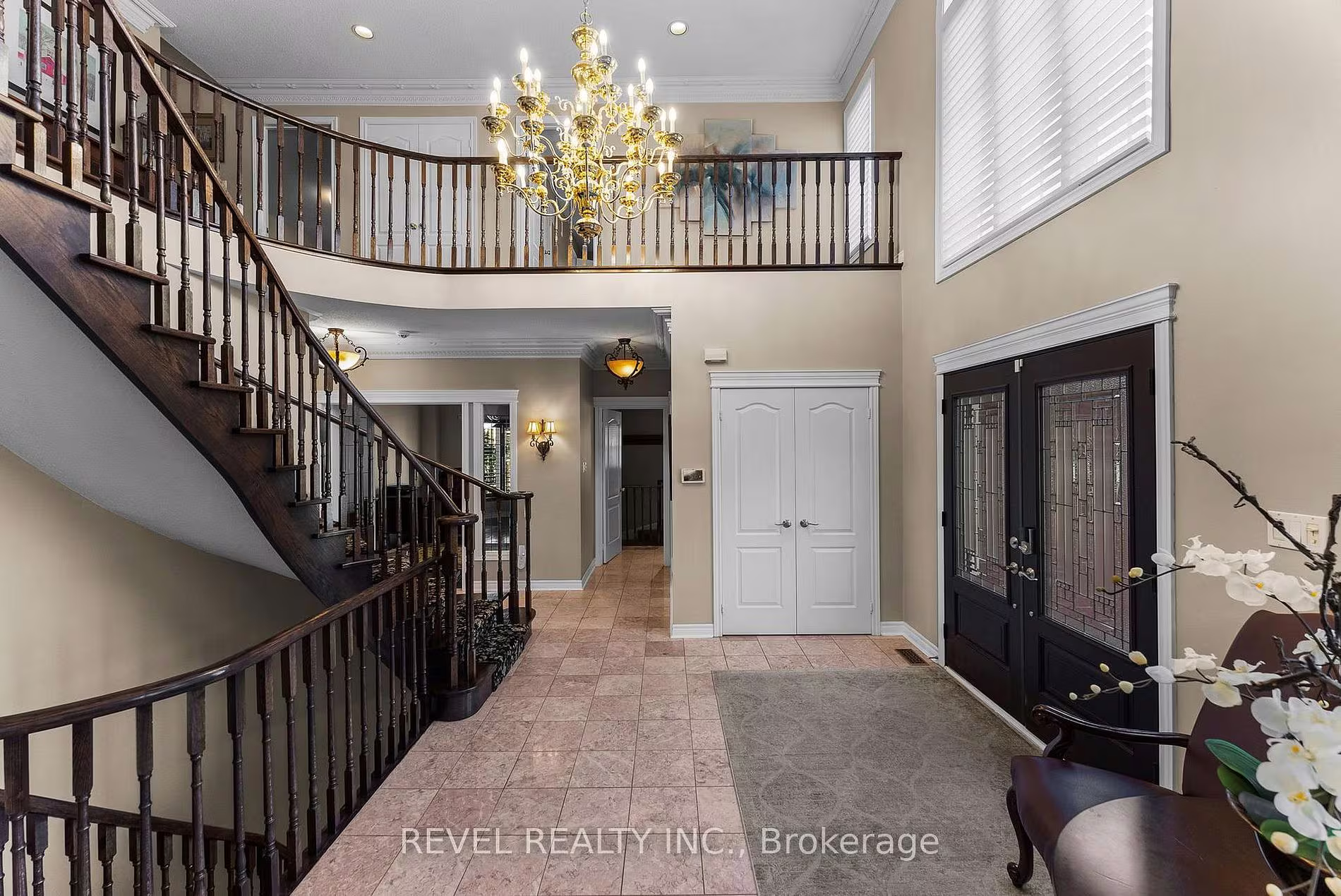 Two-storey foyer with a curved staircase and crystal chandelier at 1486 Ashwood Gate, Pickering, listed by The Gordon Brothers Team, Revel Realty Inc., Brokerage