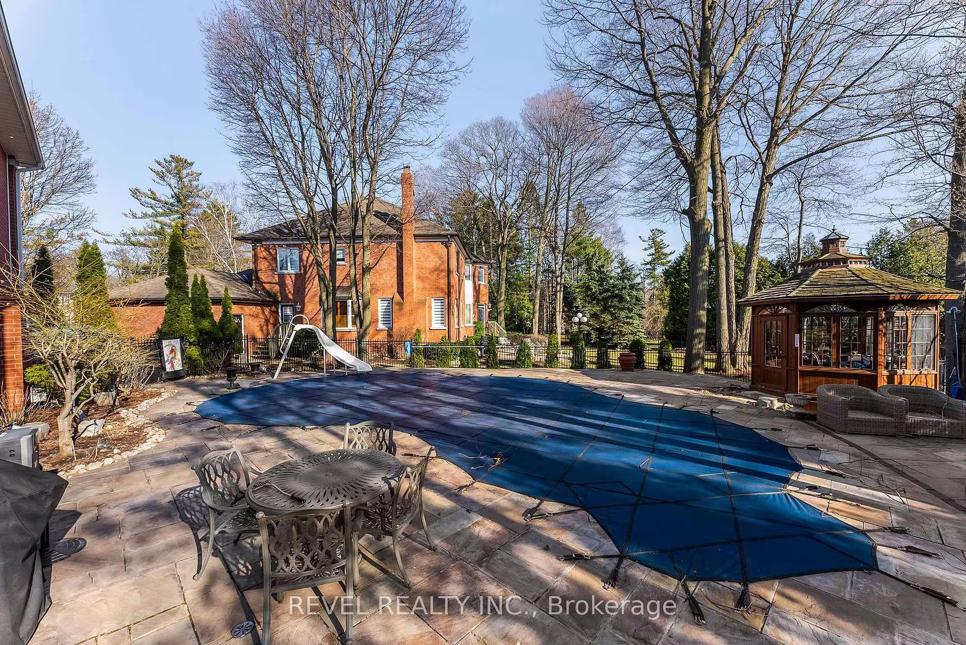 Inground pool with a slide, surrounded by mature trees at 1486 Ashwood Gate, Pickering, listed by The Gordon Brothers Team, Revel Realty Inc., Brokerage